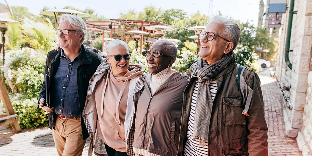 Un groupe de seniors marchent ensemble dans la rue sous le soleil