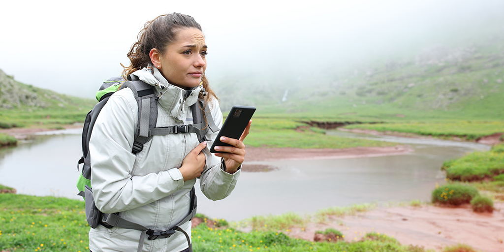 Une femme en randonnée perdue dans les montagnes.
